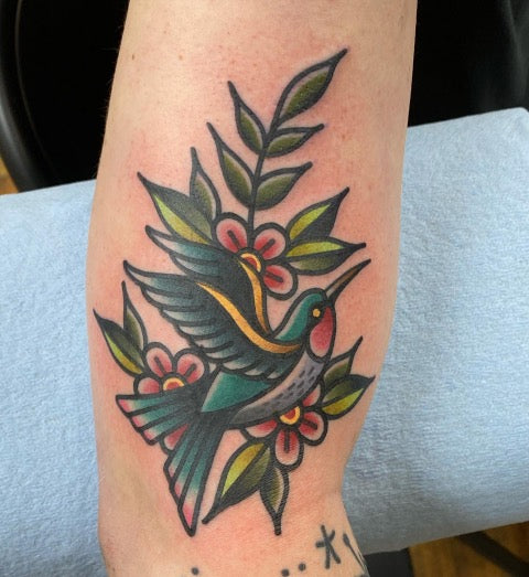 Neotraditional hummingbird tattoo on the inner forearm