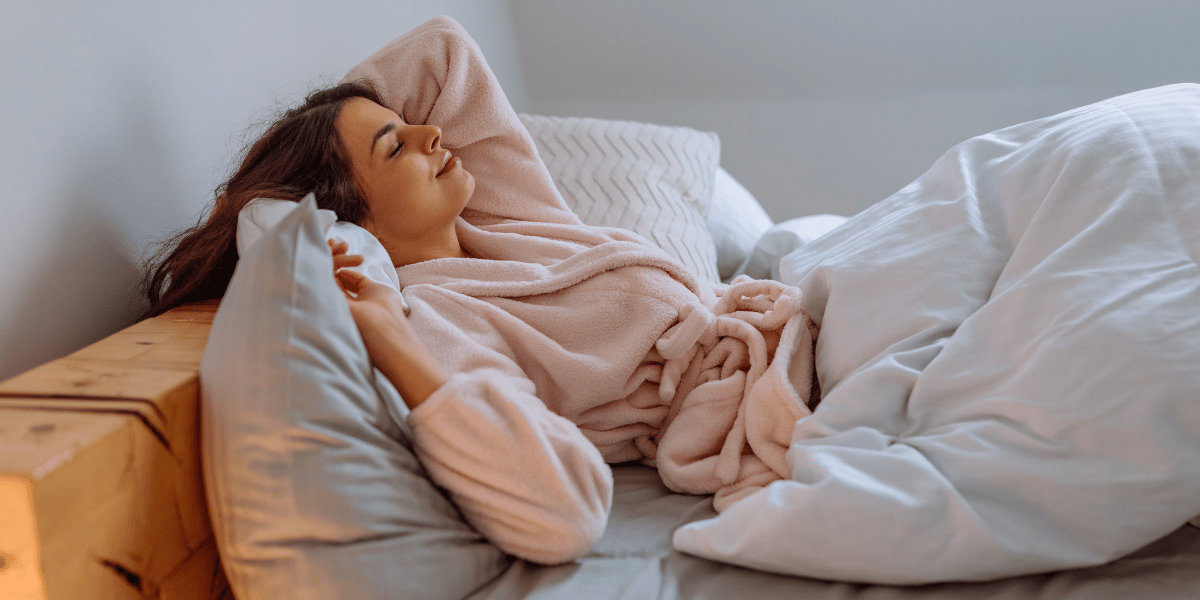 woman in a pink robe waking up from a good night's sleep