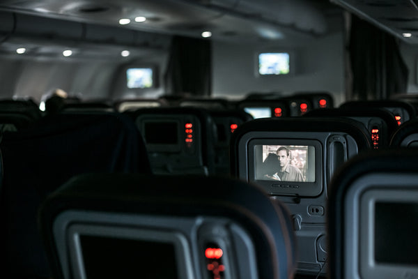Inside of an airplane with passenger watching films