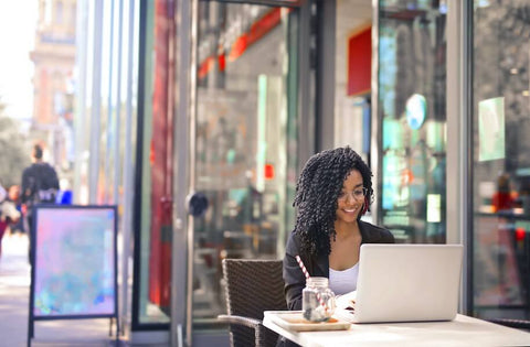 Freelancer Girl Working on Her Computer Outside a Cafe