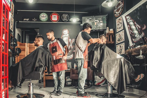 Two Male Hairdressers Cutting Hair in a Barber Shop