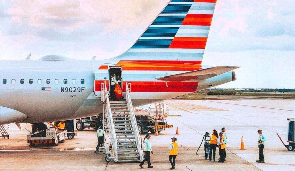 Workers Standing Next to an Airplane Waiting for Incoming Flight