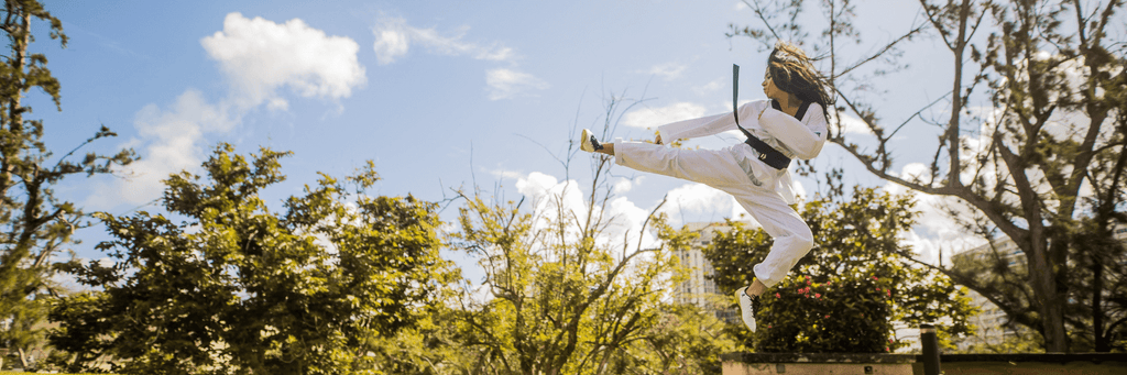 Girl in karate outfit up in the air