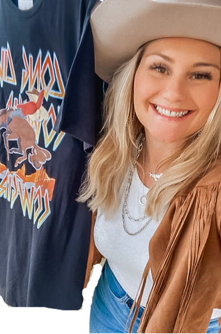 Blonde woman wearing a cowboy hat smiling next to a printed graphic dress