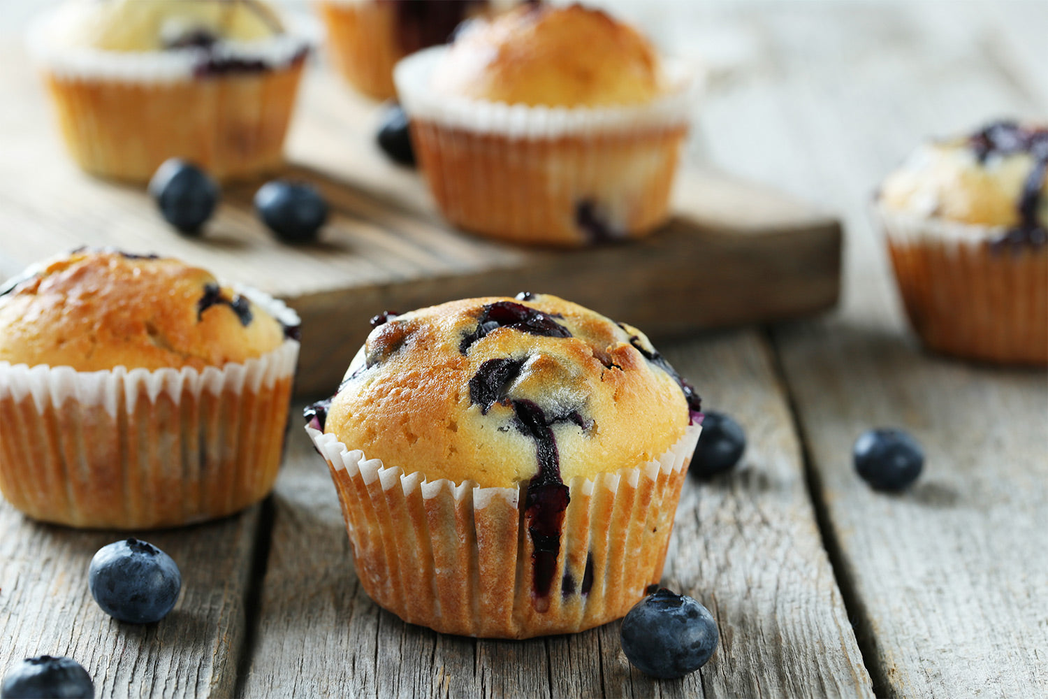 blueberry muffins on a wooden countertop