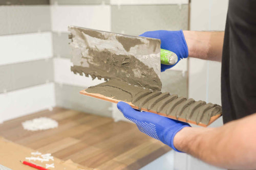 A worker placing new adhesive on the wall