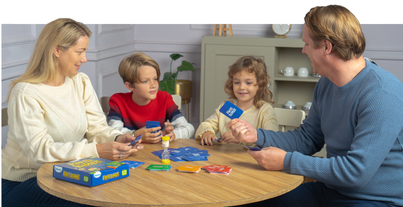 Family wearing sweaters sitting around a wooden table and playing Rapid Rumble game by Skillmatics