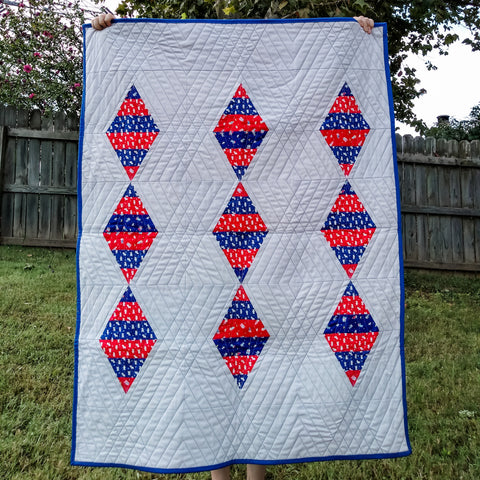 Baby quilt red and blue diamonds on a gray background