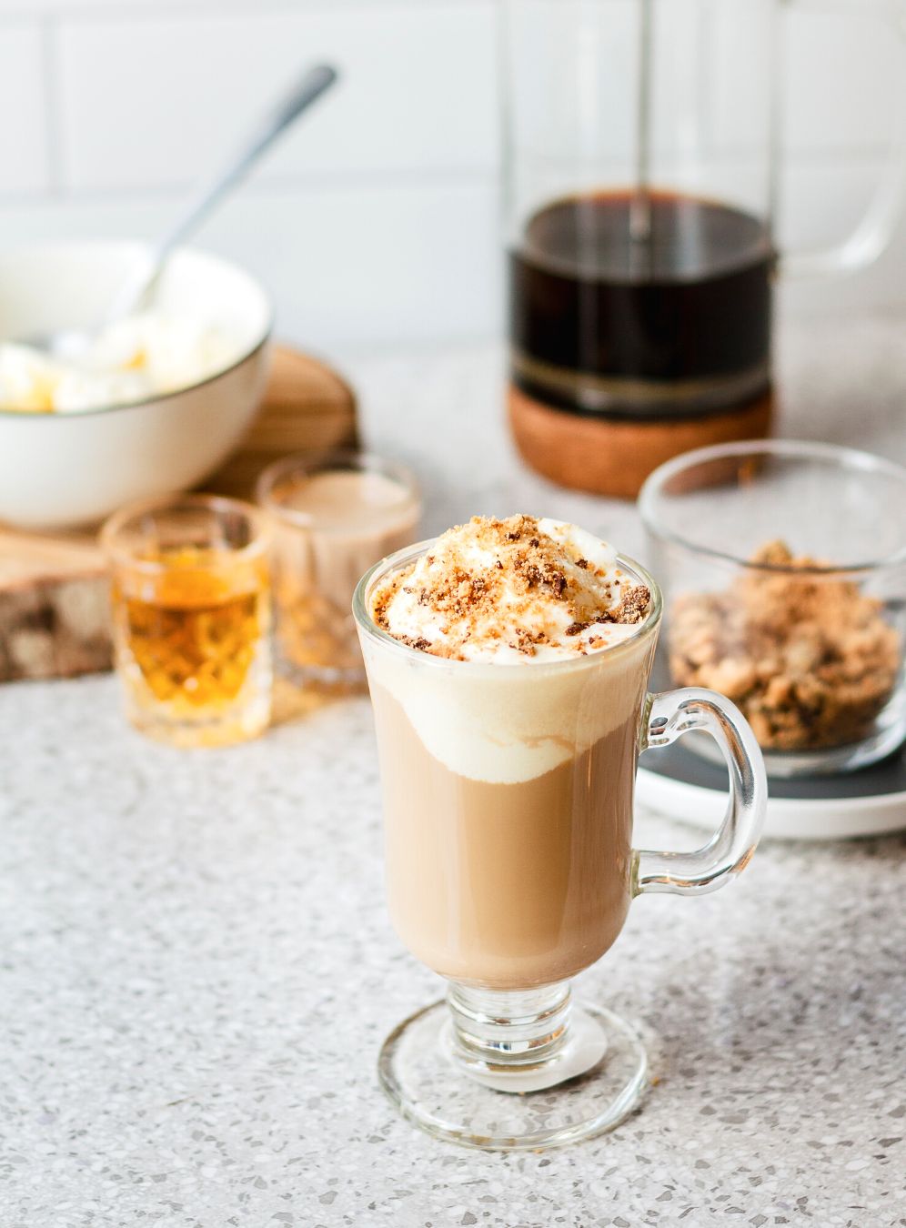 A mug of Cookie Dough Alcoholic Float sits with the ingredients on the counter