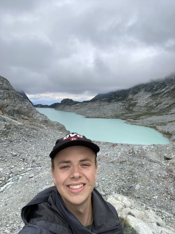 Portrait of Zachary Kruizinga hiking on a scenic trail, surrounded by lush greenery and mountains in the background.