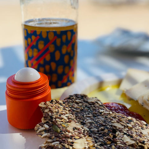 Oranges Solmates Refillable Sunscreen Applicator with food and a bottle of wine at Mallorca's Pataki restaurant