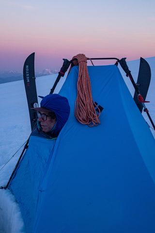 the guide stays warm in his tent while the sunsets on the glaciers of mount baker