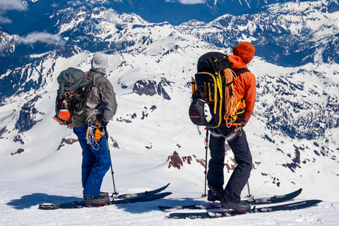 guide and guest stand on the summit overlooking the mount baker ski area