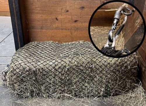 Small Bale Net secured in barn on stall mats.