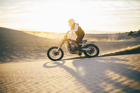 rider driving through sand