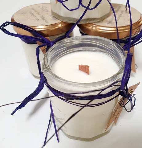 white wax candle with a wooden wick in a clear glass jar