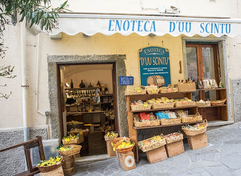 store front with lots of wicker baskets sitting in front of it and on shelves filled with wares the shop is selling