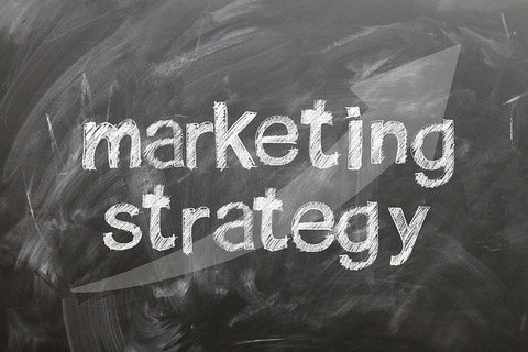 white chalk text on blackboard that says marketing strategy