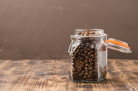 Fresh whole bean coffee in a clear air tight container