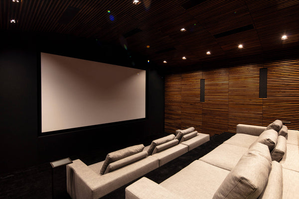 luxury home theater with couches and wood slat wall paneling