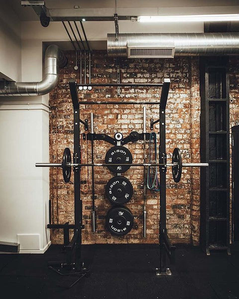 home gym accent wall using faux brick panels behind bench press rack
