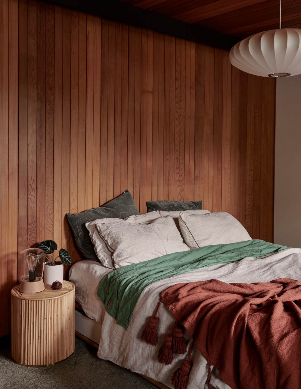 vintage bedroom with vertical wood wall panelling behind bed