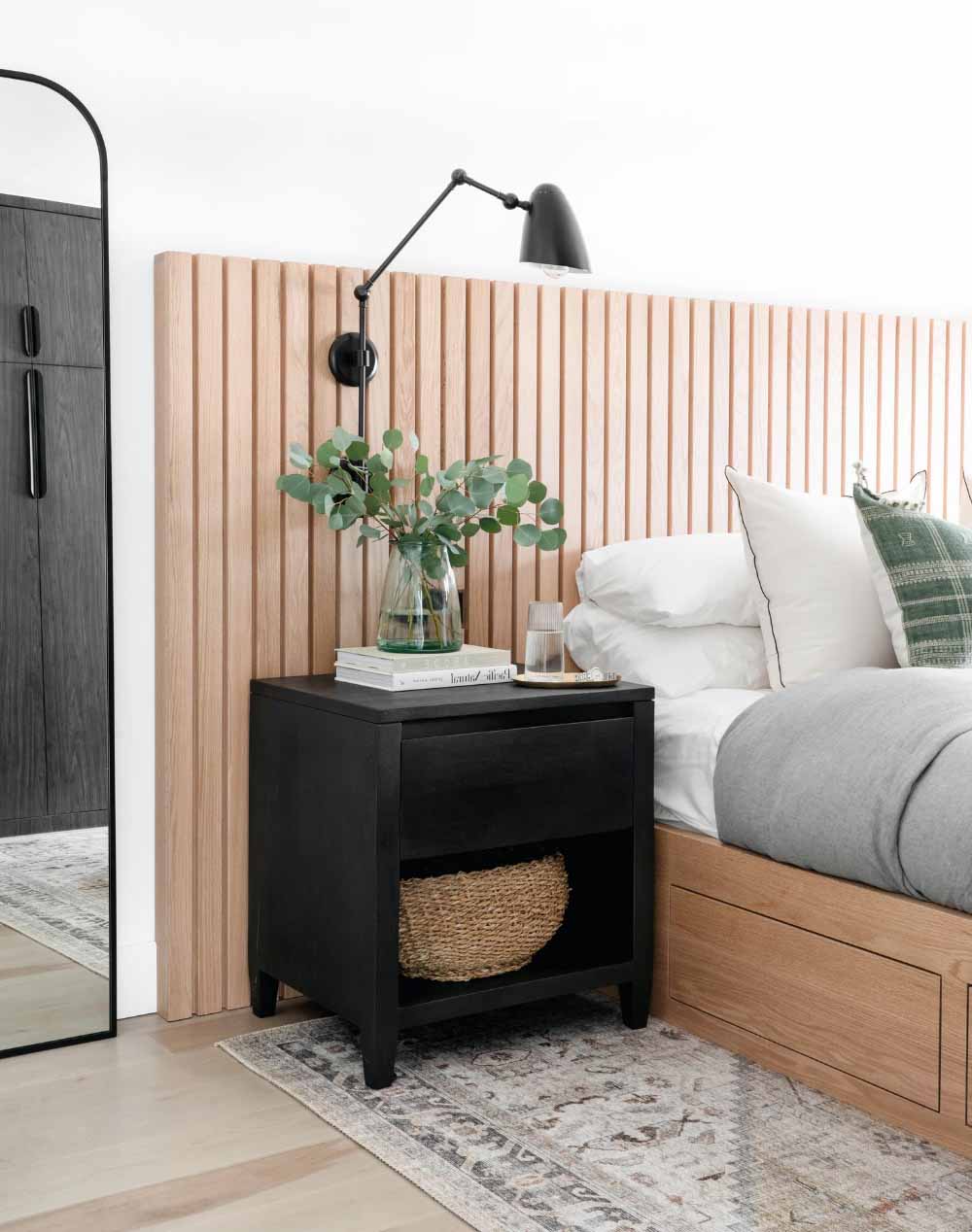 modern organic bedroom with black wall sconces and a wood slat headboard