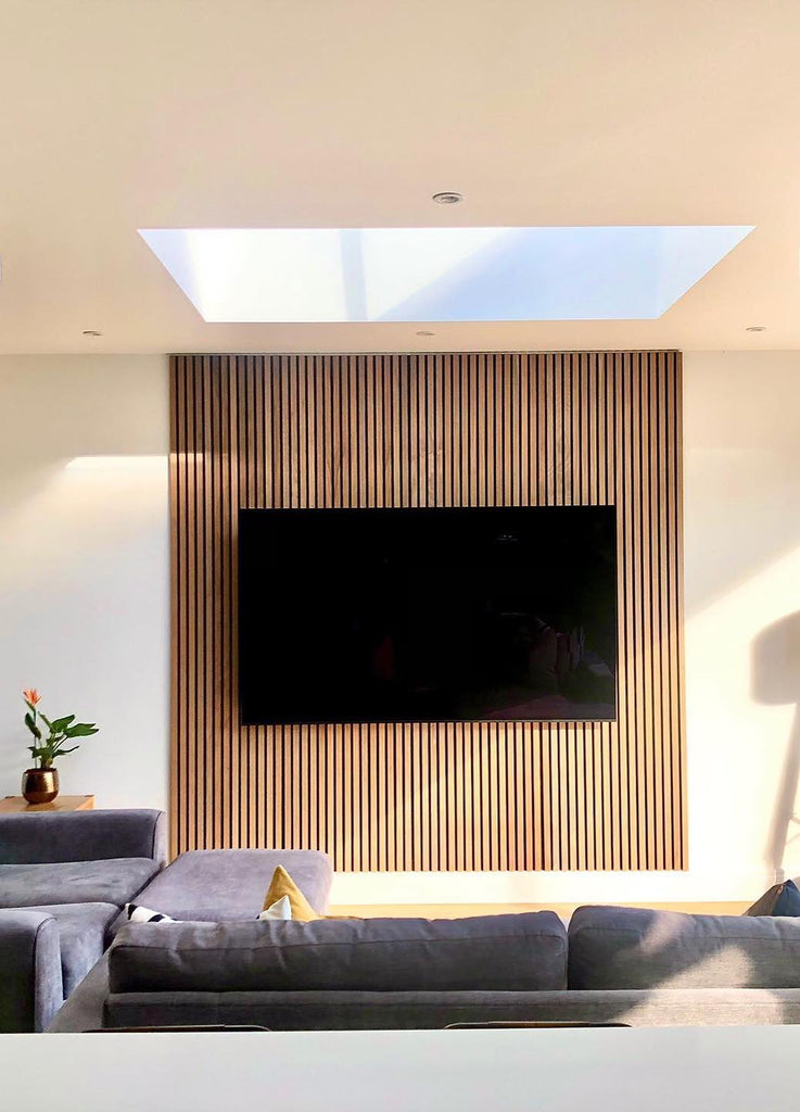 natural oak vertical wood slat accent wall behind tv in sunny living room with skylight