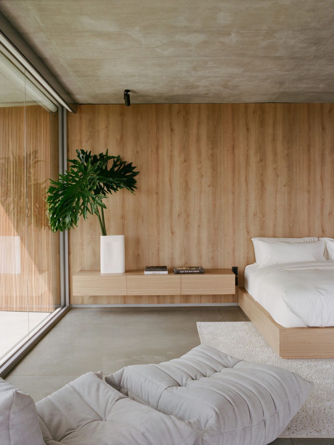 scandinavian bedroom with white oak veneer wall panelling and a solid oak bed frame with white bedding