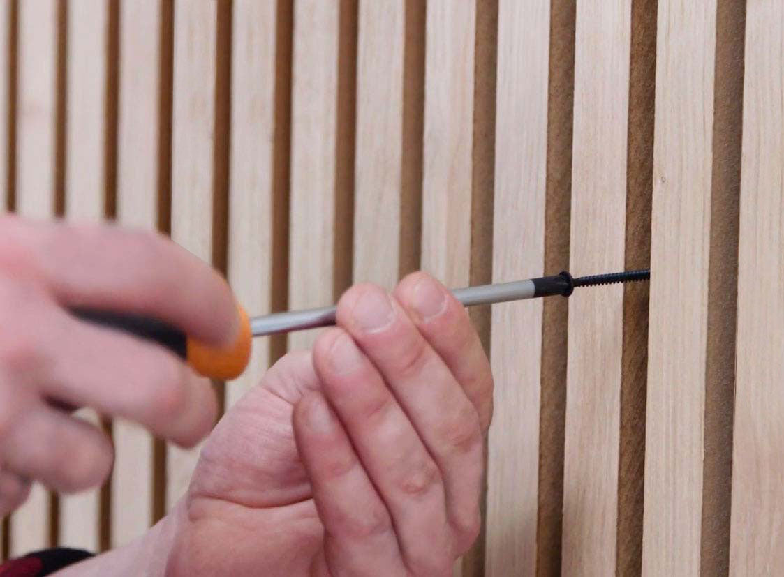 installing wood slat wall panels with a screw driver