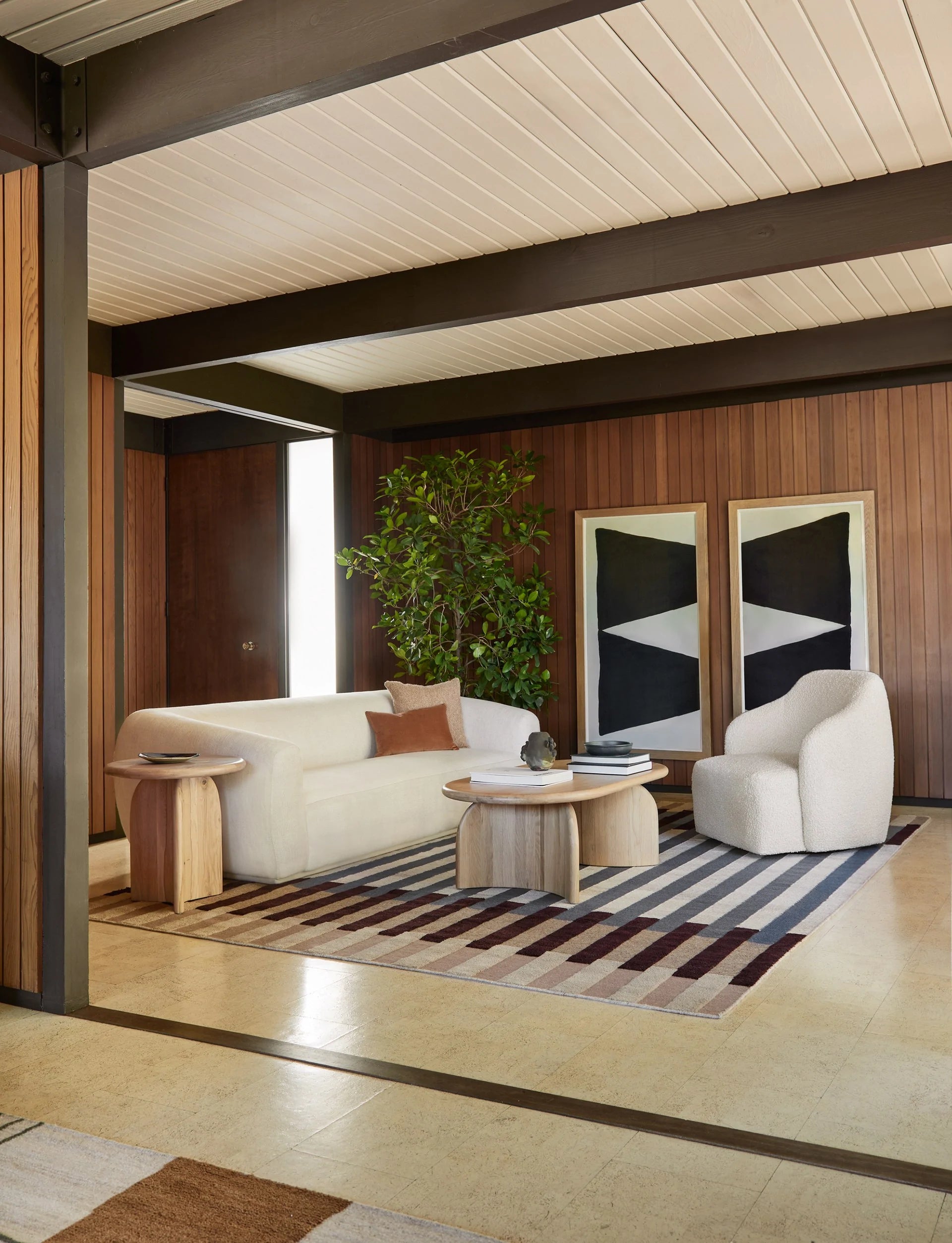 midcentury living room with vertical walnut wood wall panelling and curved furniture