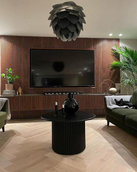 mid-century modern living room with built in walnut wood slat tv wall and plants
