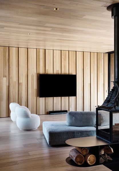 modern living room with italian furniture and a natural oak plank accent wall behind a wall-mounted TV with a fireplace