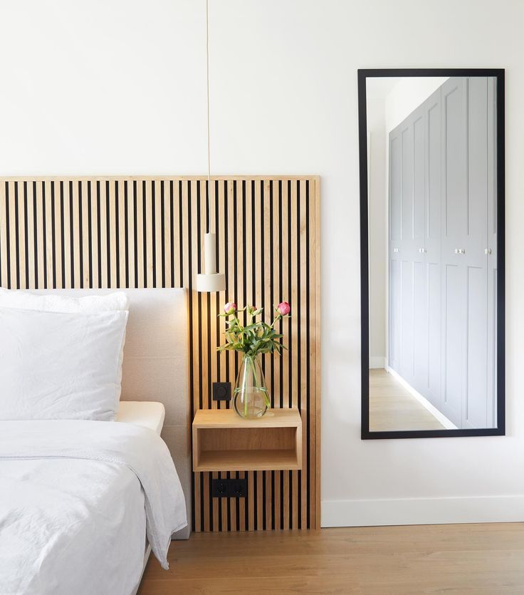 modern bedroom with vertical wood slat wall panels behind bed