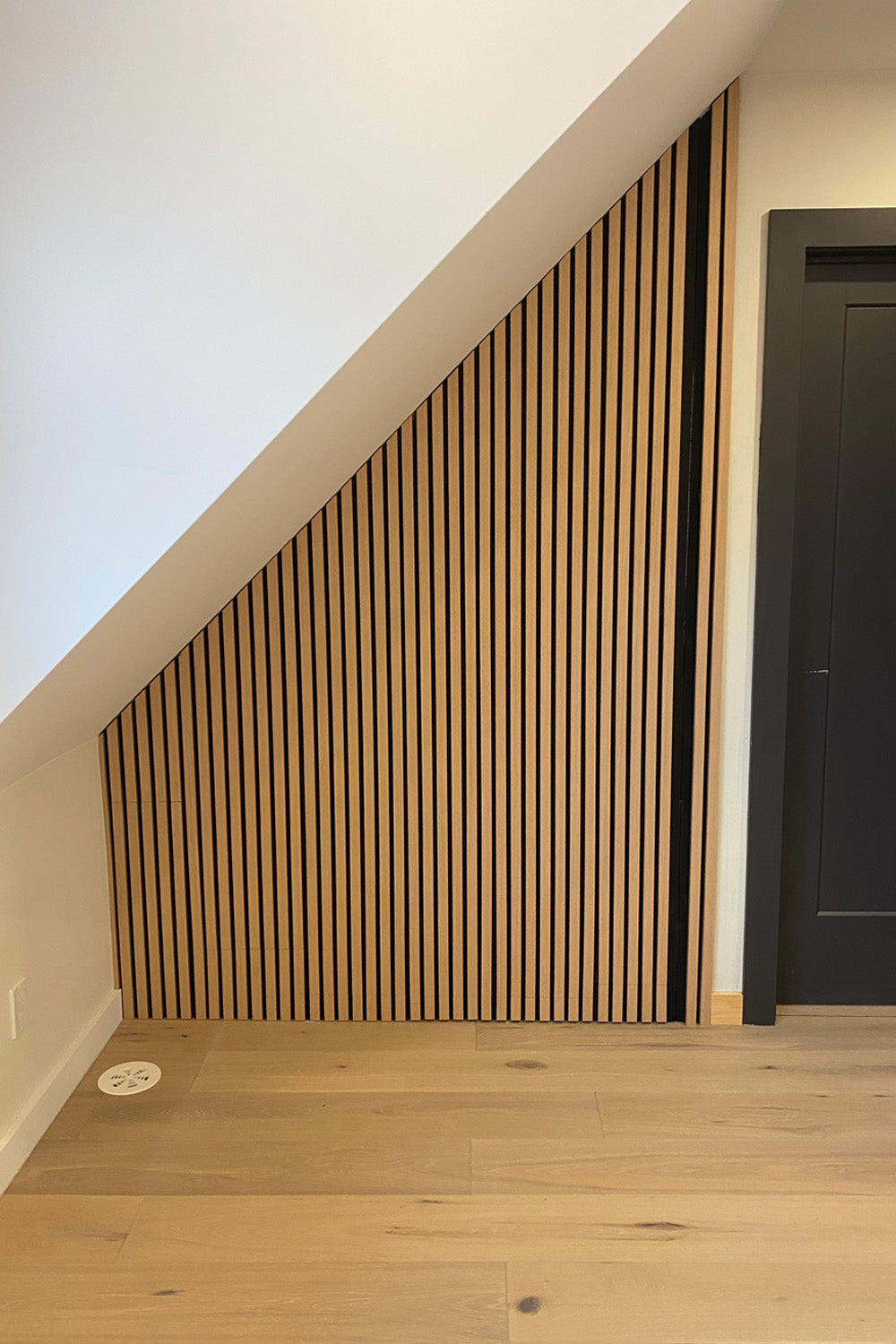 angular interior wall with white oak wood slats and white oak plank flooring
