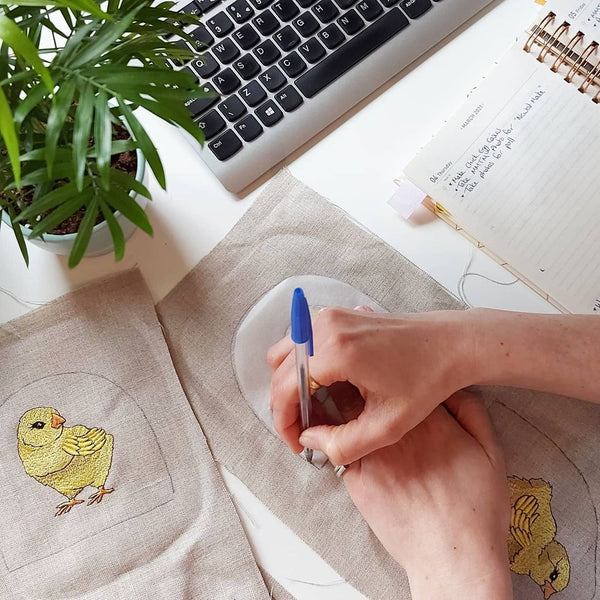 Product samples embroidered with a chick motif on a desk