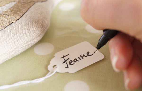 Hand and pen writing a name tag