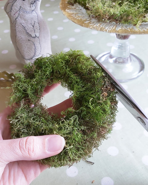 Cutting a ring out of dried moss for a table centre piece