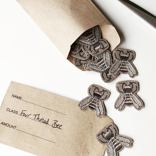 Embroidered bee charms falling out of an envelope by Kate Sproston Design