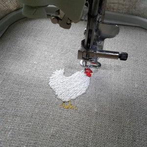 Cockerel being stitched using a digital embroidery machine.