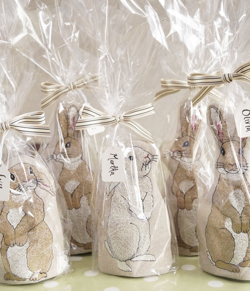 A group of embroidered rabbit egg cosies by Kate Sproston Design wrapped in cellophane and tied with a bow