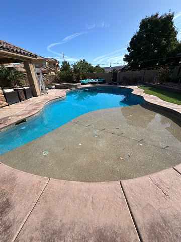 Recently remodeled pool with sparking blue water and a pebble finish shelf.