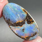A loose, oval cabochon cut boulder opal stone from Queensland, Australia.