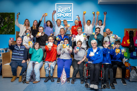 Das gesamte Team nach dem erfolgreichen Schoko-Workshop zeigen glücklich ihre handgefertigte Schokoladen.