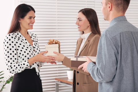 Woman receiving a gift box from her coworkers