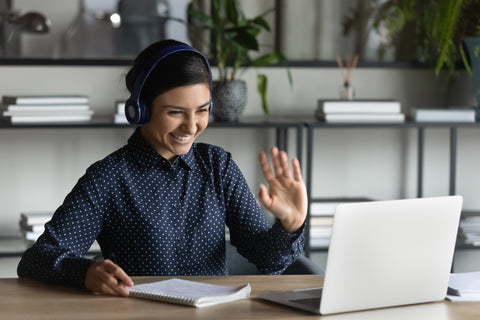 Remote worker waving at a computer screen