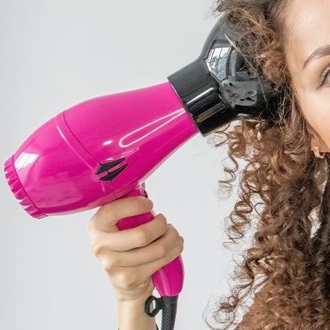 curly haired woman diffusing her hair