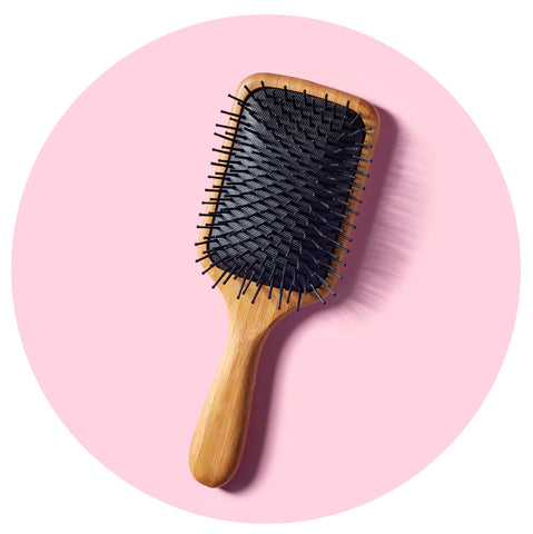 paddle brush against a pink background