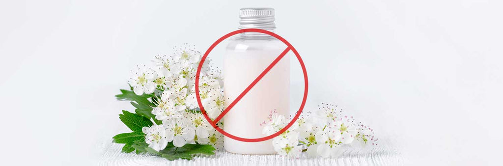 bottle of white hair product liquid with flowers surrounding