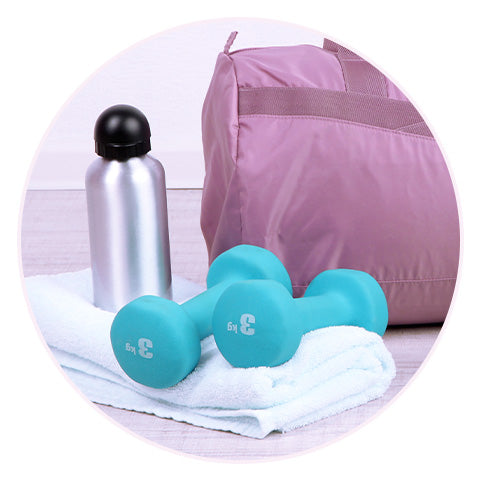 dumbbells and a water bottle sitting on top of a white towel next to a pink sports bag